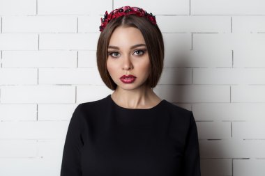 elegant beautiful sexy woman in evening dress with a bright evening make-up with full lips with red lipstick on her lips , and with a wreath of olive branches on her head