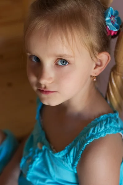 Portrait of a beautiful sweet little girl in a blue dress with blue eyes — Stock Photo, Image