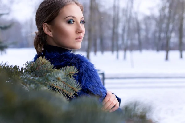 Portret van een mooi lief meisje met een mooie make-up in de buurt van de kerstboom in heldere winterdag — Stockfoto