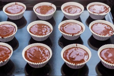 güzel shokolodnoe hamur kek kalıpları içine bir tepsiye dökülür.