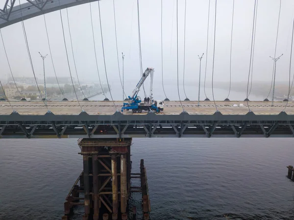 Aerial drone view. Construction of a cable-stayed bridge across the river in dense fog.