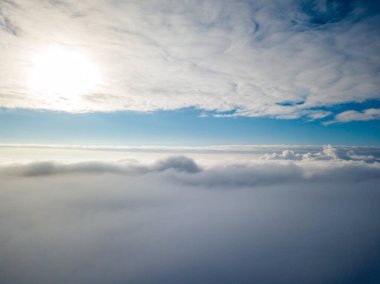 Hava görüntüsü. Güneşli bir havada, beyaz bulutların üzerinde uçuyor..