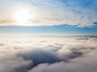 Hava görüntüsü. Güneşli bir havada, beyaz bulutların üzerinde uçuyor..