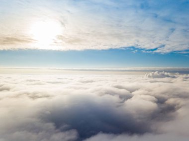 Hava görüntüsü. Güneşli bir havada, beyaz bulutların üzerinde uçuyor..