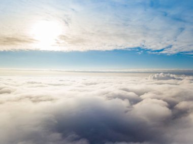 Hava görüntüsü. Güneşli bir havada, beyaz bulutların üzerinde uçuyor..