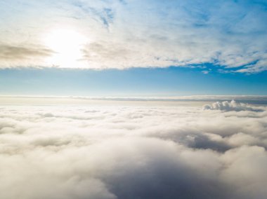 Hava görüntüsü. Güneşli bir havada, beyaz bulutların üzerinde uçuyor..