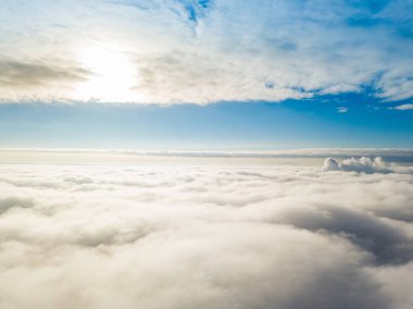Hava görüntüsü. Güneşli bir havada, beyaz bulutların üzerinde uçuyor..
