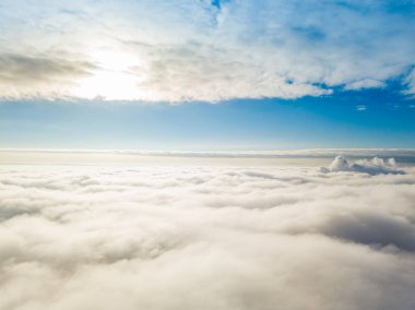 Hava görüntüsü. Güneşli bir havada, beyaz bulutların üzerinde uçuyor..