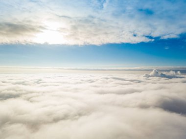 Hava görüntüsü. Güneşli bir havada, beyaz bulutların üzerinde uçuyor..