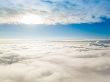 Hava görüntüsü. Güneşli bir havada, beyaz bulutların üzerinde uçuyor..