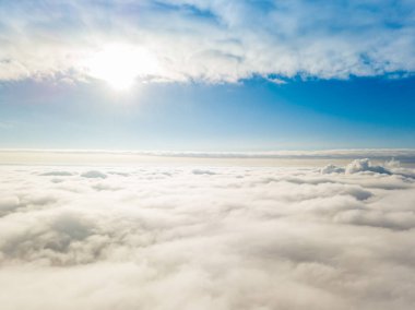 Hava görüntüsü. Güneşli bir havada, beyaz bulutların üzerinde uçuyor..