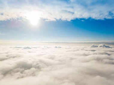 Hava görüntüsü. Güneşli bir havada, beyaz bulutların üzerinde uçuyor..