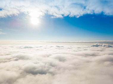 Hava görüntüsü. Güneşli bir havada, beyaz bulutların üzerinde uçuyor..