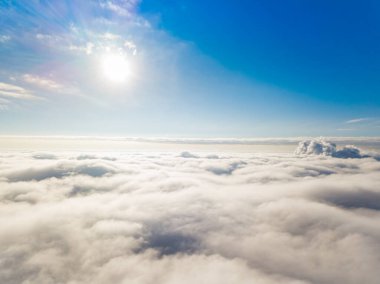 Hava görüntüsü. Güneşli bir havada, beyaz bulutların üzerinde uçuyor..