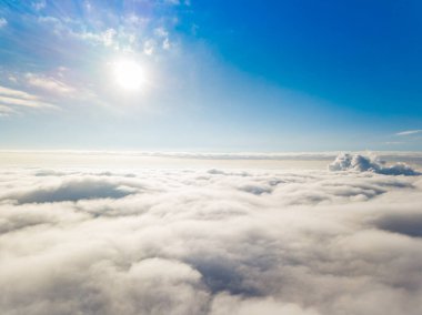 Hava görüntüsü. Güneşli bir havada, beyaz bulutların üzerinde uçuyor..