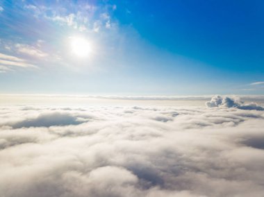 Hava görüntüsü. Güneşli bir havada, beyaz bulutların üzerinde uçuyor..