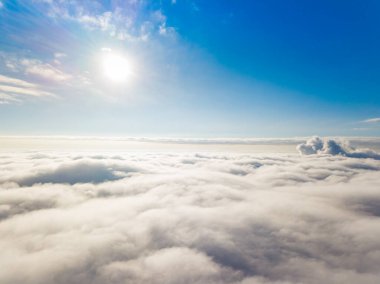 Hava görüntüsü. Güneşli bir havada, beyaz bulutların üzerinde uçuyor..