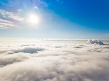 Hava görüntüsü. Güneşli bir havada, beyaz bulutların üzerinde uçuyor..