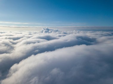 Hava görüntüsü. Güneşli bir havada, beyaz bulutların üzerinde uçuyor..