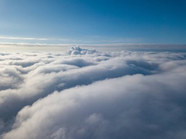 Hava görüntüsü. Güneşli bir havada, beyaz bulutların üzerinde uçuyor..