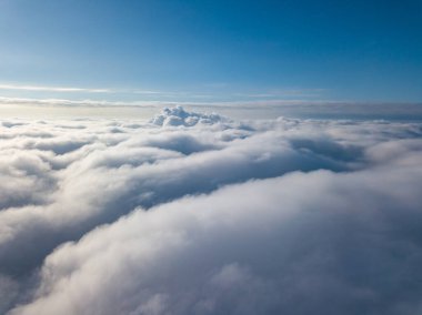 Hava görüntüsü. Güneşli bir havada, beyaz bulutların üzerinde uçuyor..