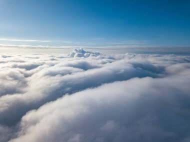 Hava görüntüsü. Güneşli bir havada, beyaz bulutların üzerinde uçuyor..