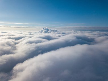 Hava görüntüsü. Güneşli bir havada, beyaz bulutların üzerinde uçuyor..