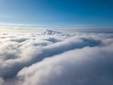 Hava görüntüsü. Güneşli bir havada, beyaz bulutların üzerinde uçuyor..