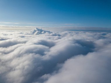 Hava görüntüsü. Güneşli bir havada, beyaz bulutların üzerinde uçuyor..