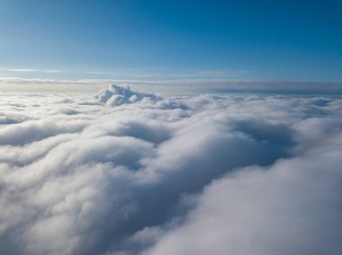 Hava görüntüsü. Güneşli bir havada, beyaz bulutların üzerinde uçuyor..