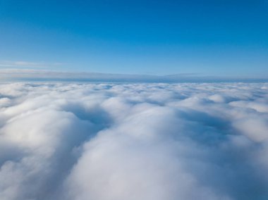 Hava görüntüsü. Güneşli bir havada, beyaz bulutların üzerinde uçuyor..