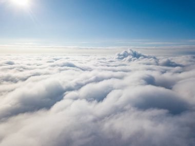 Hava görüntüsü. Güneşli bir havada, beyaz bulutların üzerinde uçuyor..