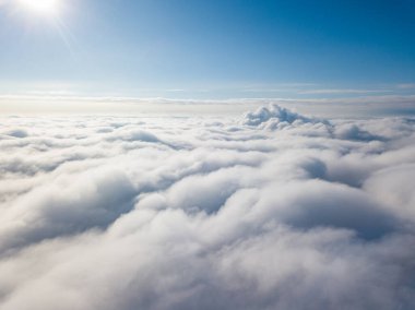 Hava görüntüsü. Güneşli bir havada, beyaz bulutların üzerinde uçuyor..