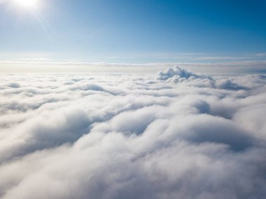 Hava görüntüsü. Güneşli bir havada, beyaz bulutların üzerinde uçuyor..