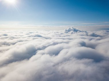 Hava görüntüsü. Güneşli bir havada, beyaz bulutların üzerinde uçuyor..