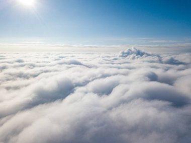 Hava görüntüsü. Güneşli bir havada, beyaz bulutların üzerinde uçuyor..