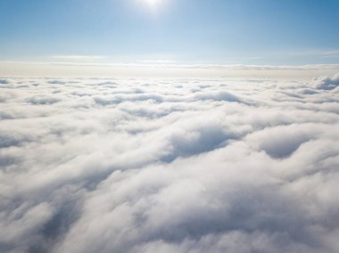 Hava görüntüsü. Güneşli bir havada, beyaz bulutların üzerinde uçuyor..