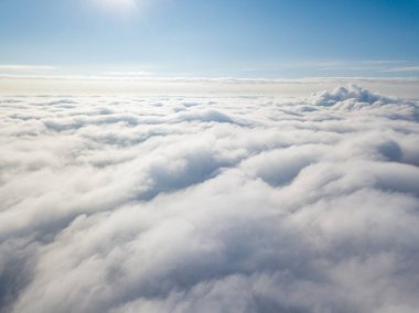 Hava görüntüsü. Güneşli bir havada, beyaz bulutların üzerinde uçuyor..