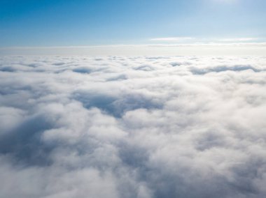 Hava görüntüsü. Güneşli bir havada, beyaz bulutların üzerinde uçuyor..