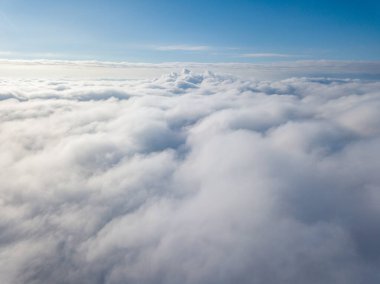 Hava görüntüsü. Güneşli bir havada, beyaz bulutların üzerinde uçuyor..