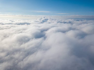 Hava görüntüsü. Güneşli bir havada, beyaz bulutların üzerinde uçuyor..