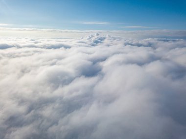Hava görüntüsü. Güneşli bir havada, beyaz bulutların üzerinde uçuyor..