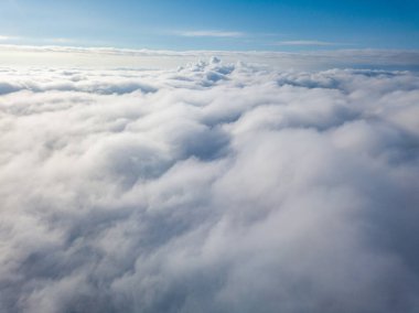 Hava görüntüsü. Güneşli bir havada, beyaz bulutların üzerinde uçuyor..