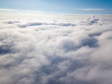 Hava görüntüsü. Güneşli bir havada, beyaz bulutların üzerinde uçuyor..
