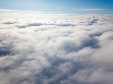 Hava görüntüsü. Güneşli bir havada, beyaz bulutların üzerinde uçuyor..
