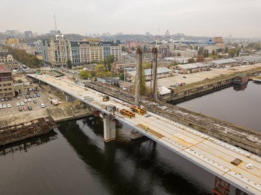 Hava aracı görüntüsü. Kiev 'de Dinyeper nehri üzerinde bir köprü inşa ediliyor. Bulutlu bir sonbahar sabahı.