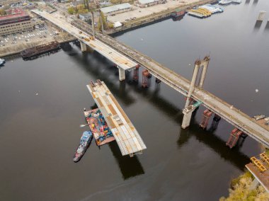 Hava aracı görüntüsü. Kiev 'de Dinyeper nehri üzerinde bir köprü inşa ediliyor. Bulutlu bir sonbahar sabahı.
