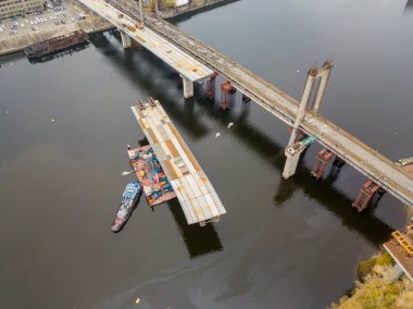 Hava aracı görüntüsü. Kiev 'de Dinyeper nehri üzerinde bir köprü inşa ediliyor. Bulutlu bir sonbahar sabahı.