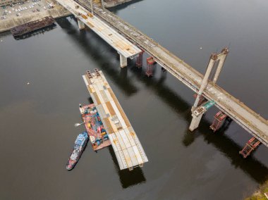 Hava aracı görüntüsü. Kiev 'de Dinyeper nehri üzerinde bir köprü inşa ediliyor. Bulutlu bir sonbahar sabahı.