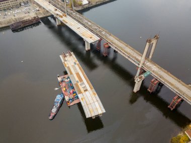 Hava aracı görüntüsü. Kiev 'de Dinyeper nehri üzerinde bir köprü inşa ediliyor. Bulutlu bir sonbahar sabahı.
